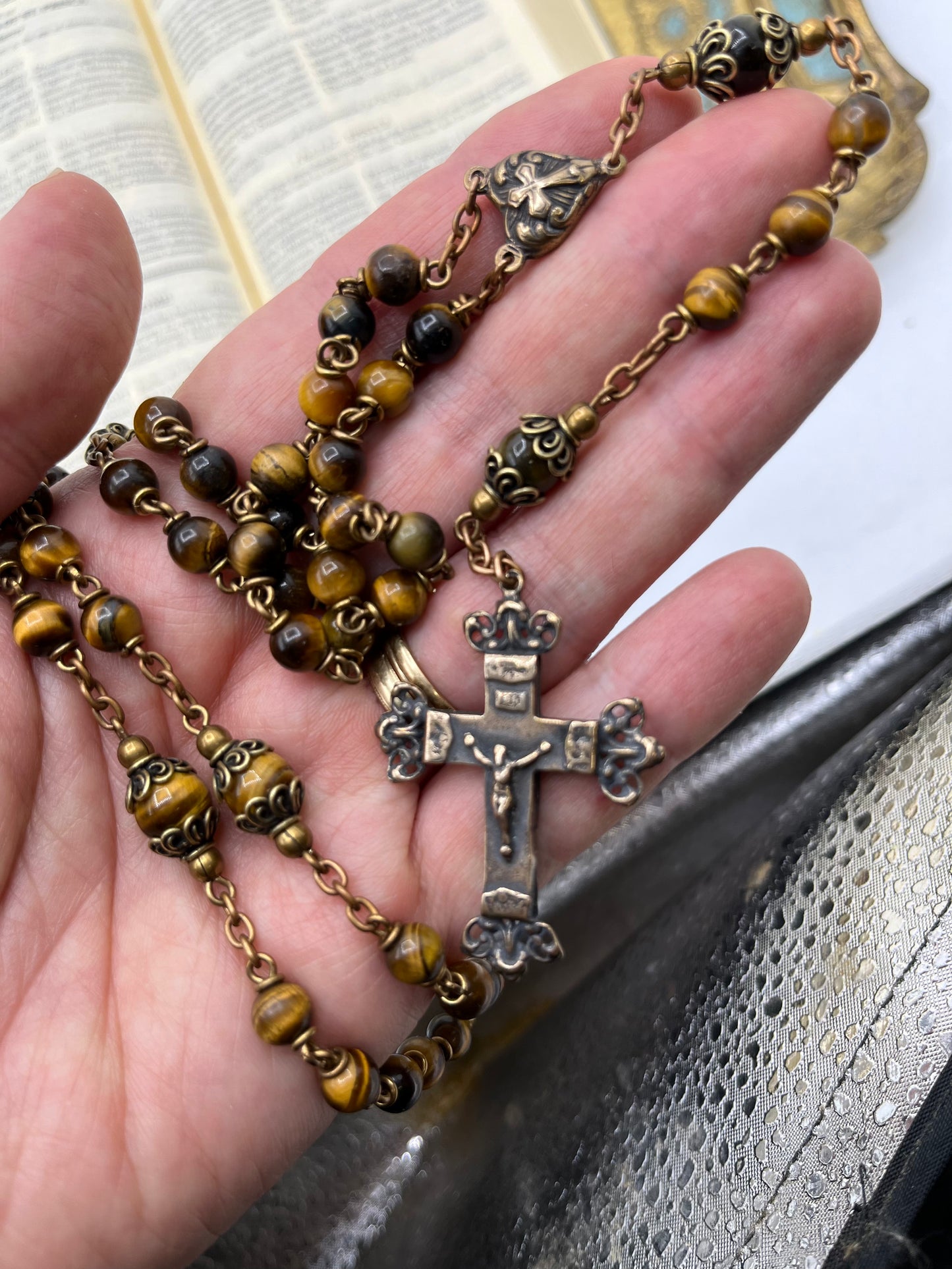 Detail of thick bronze wire and durable chain connecting decades on a handmade Gold Tiger Eye Catholic rosary.