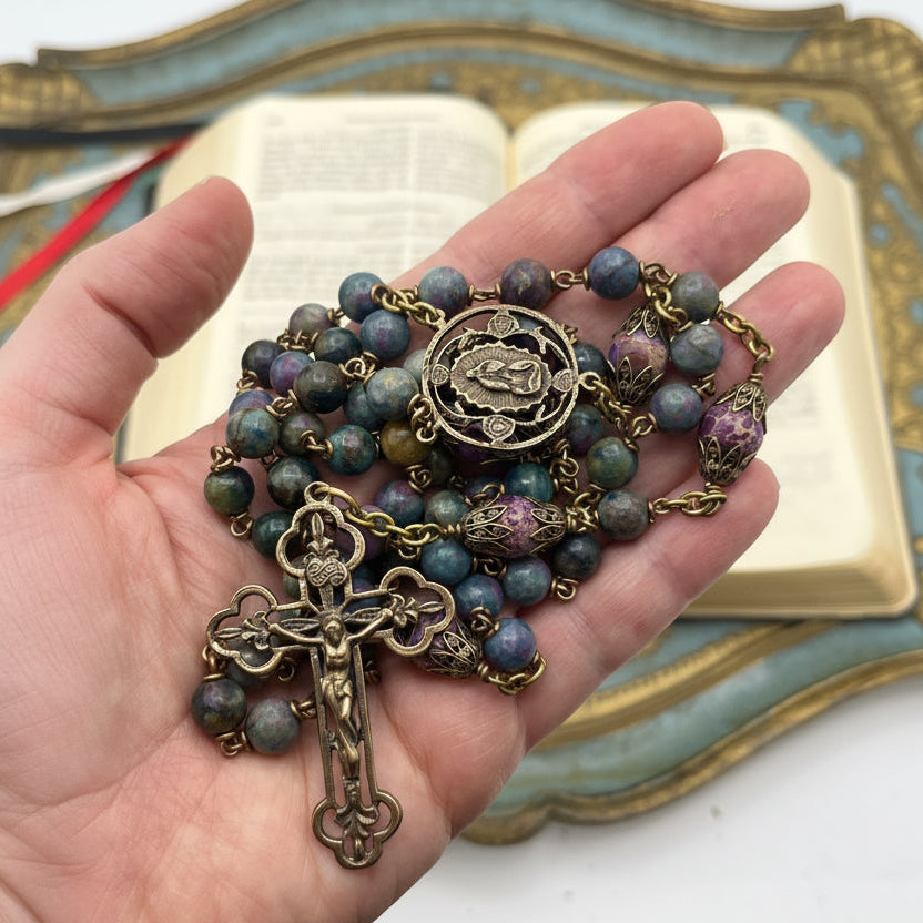 Hand holding a handmade ruby zoisite and purple jasper Catholic rosary showing size and craftsmanship with solid bronze components