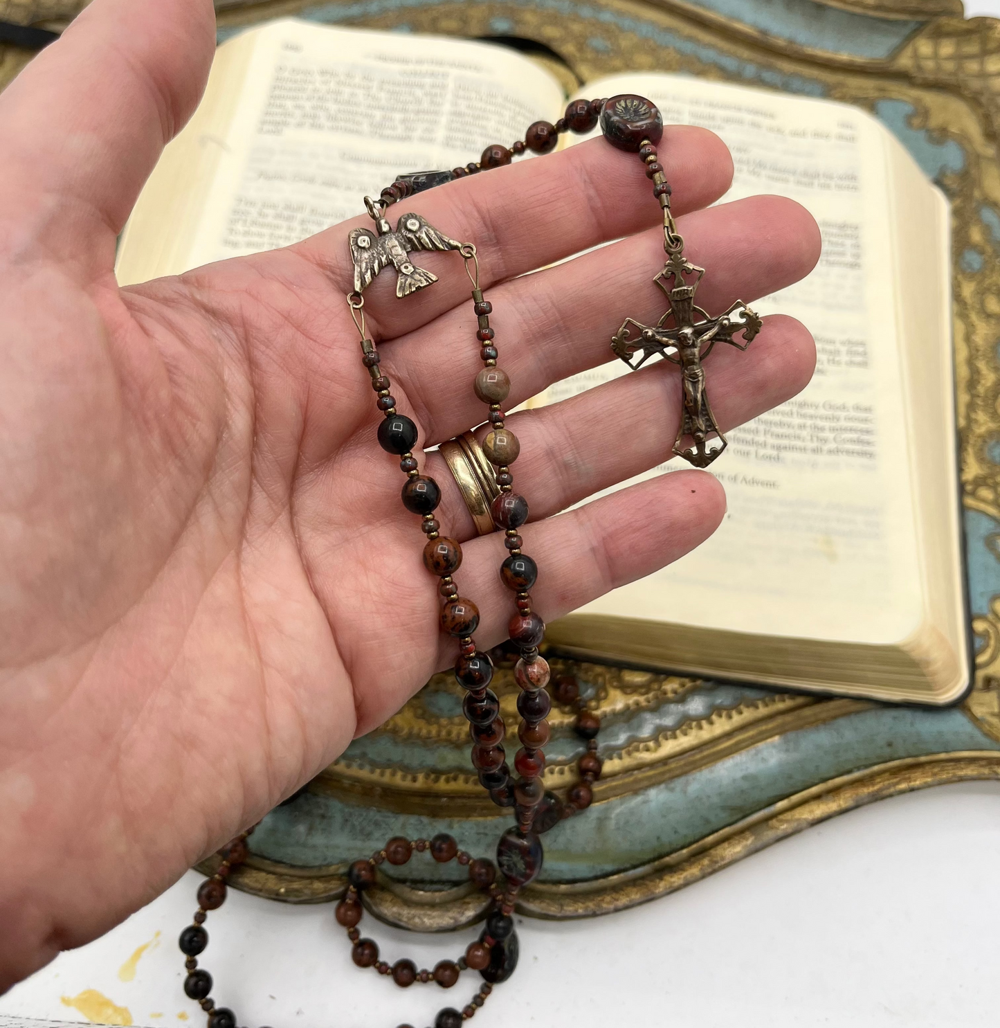 Hand holds Red Brecciated Jasper Confirmation rosary with Catholic prayer book