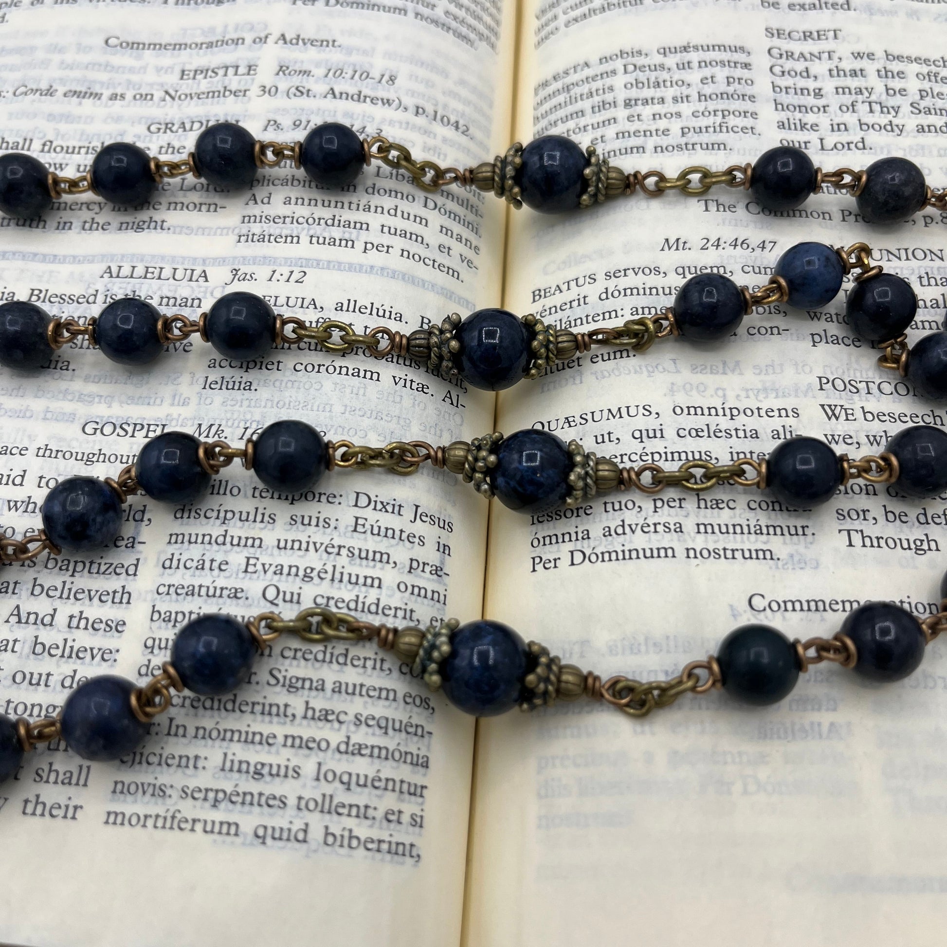 Close up of 10mm Dumortierite Our Father beads with bronze bead caps on hand wired heirloom rosary