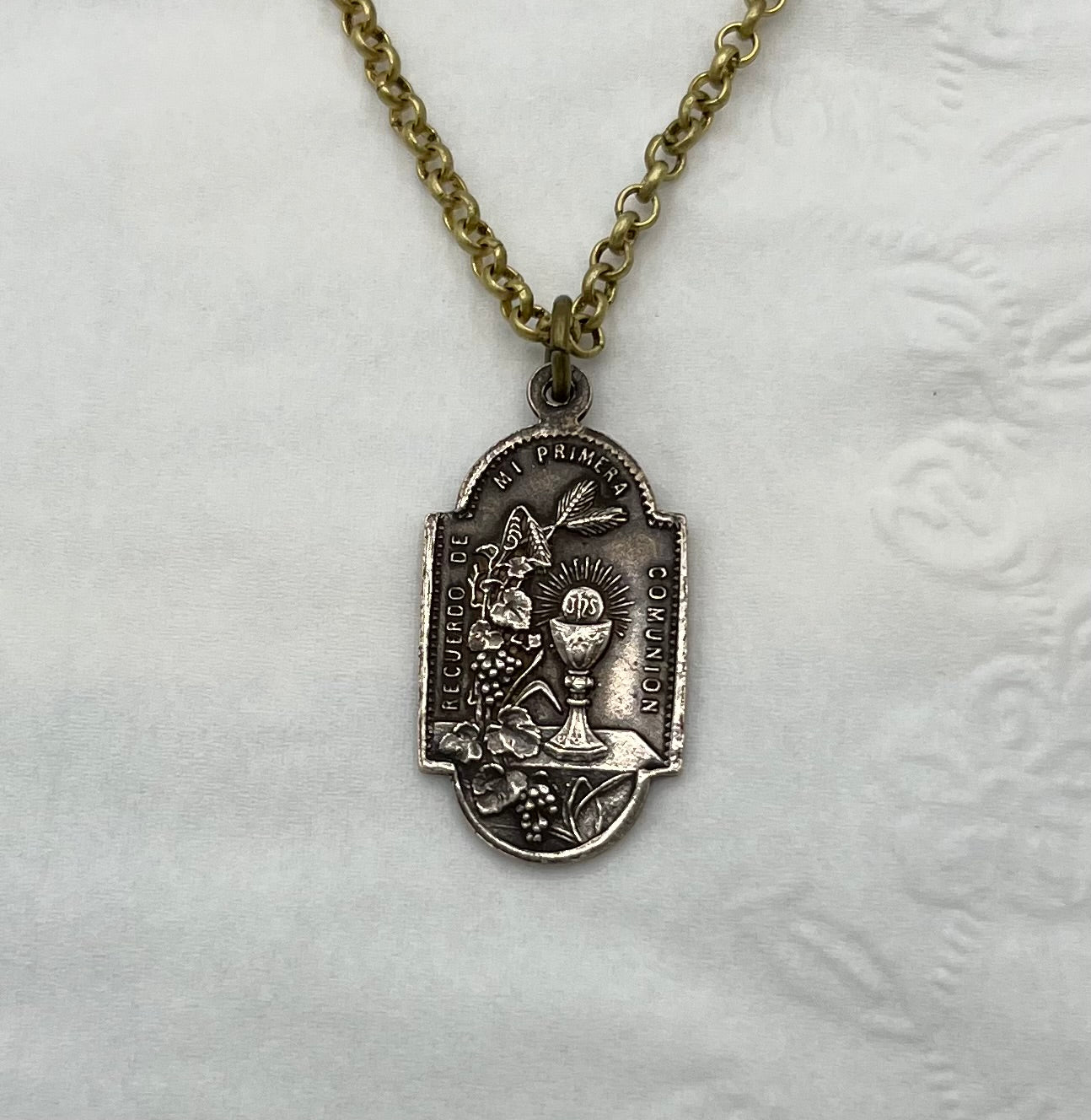 Reverse side of First Holy Communion medal necklace showing chalice and wheat design, 1-inch solid bronze hand cast pendant