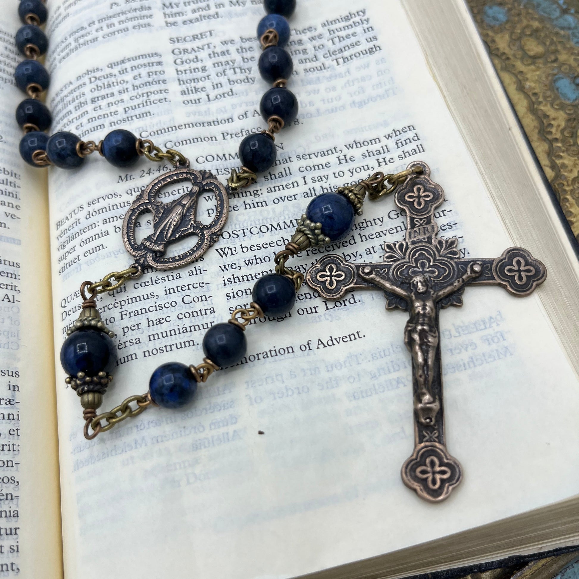 Close up of solid bronze crucifix and Miraculous Medal center on handcrafted Dumortierite gemstone rosary